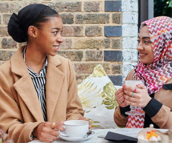 Young Muslim Friends Talking At A Cafe